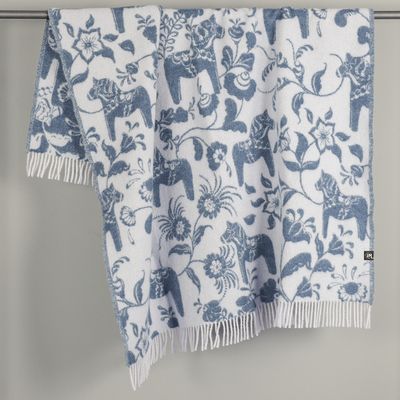 Blå pläd med dalahästar och blomster draperad över stång