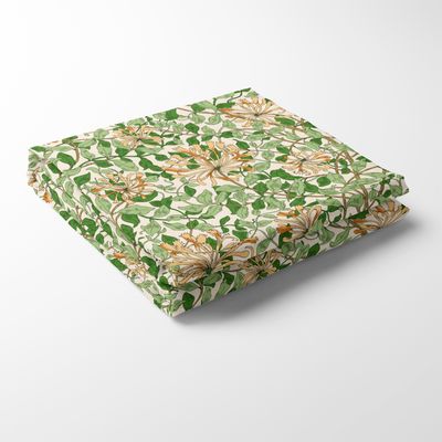 Bordsduk i Honeysuckle aprikos med blommigt mönster i grönt och aprikos på ljus botten, i 100 % bomull.