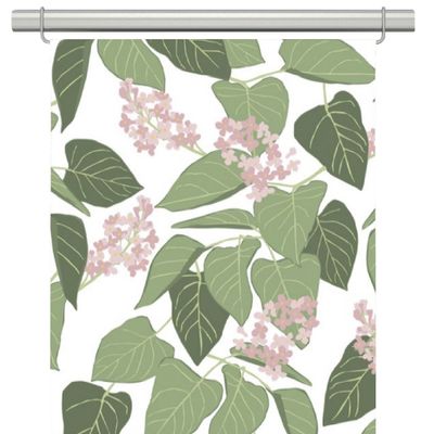 Vid fikabordet panelgardiner, fint mönster med vit botten och rosa blommor och gröna blad.