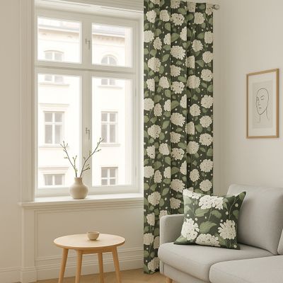 Hortensia grön gardin hängandes vid ett fönster med matchande kudde på ljusgrå soffa i ett ljust vardagsrum.