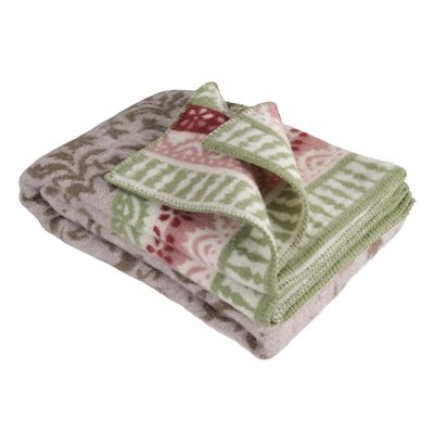 Närbild av Torpet ullfilt som visar dekorativa bårder i grönt och rött samt mjuk lammullskvalitet.