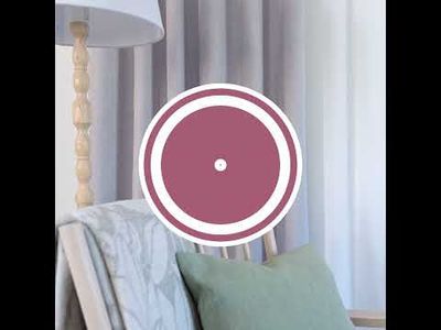 Video med långsam kamerarörelse i vardagsrumsmiljö med Cru ljusgrå mörkläggningsgardin, ljus träfåtölj, kudde, pläd, kaffekopp och färgprover på runt bord.