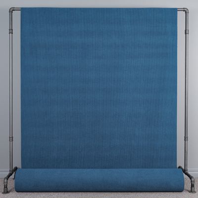 Hel vy av blått manchestertyg Huggy upphängt på tygställning.