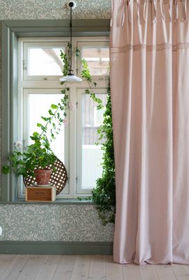 Ljusrosa knytbandsgardin som ger ett mjukt och ombonat uttryck vid fönster