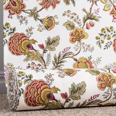 Tyg rullat med klassiskt blommönster i vinrött och varma toner