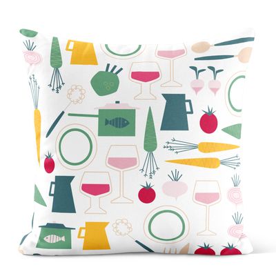 Kuddfodral med grafiskt mönster av köksföremål, vinglas och grönsaker i grönt, gult och rosa på ljus botten