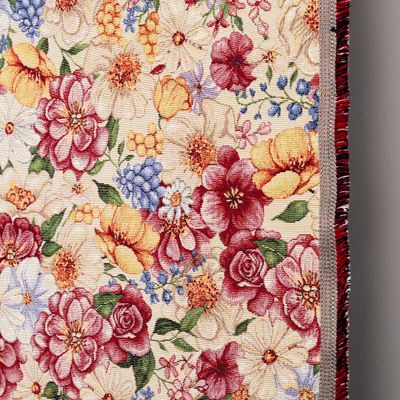 Detaljbild av Spring Bloom gobeläng som visar vävens struktur och tygkant med färgstarka blommor.