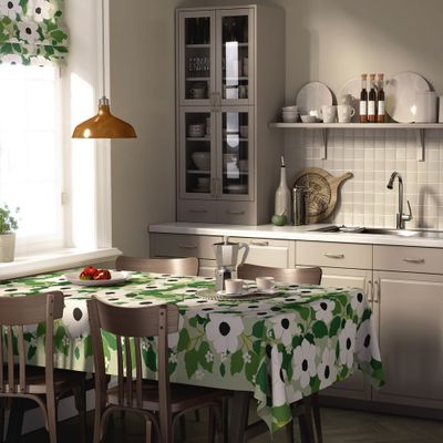 Svartöga grön bordsduk med vitt blommönster dukad på matbord i ljust kök