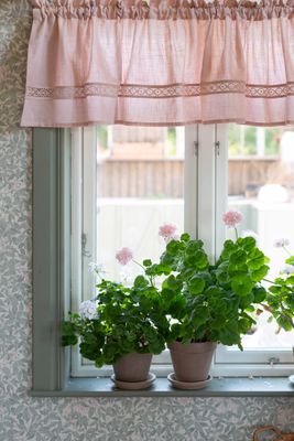 Rosa gardinkappa Sanna upphängd i fönster som skapar en romantisk och ombonad känsla