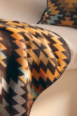 Närbild på filtens struktur och mönster i varm färgskala.