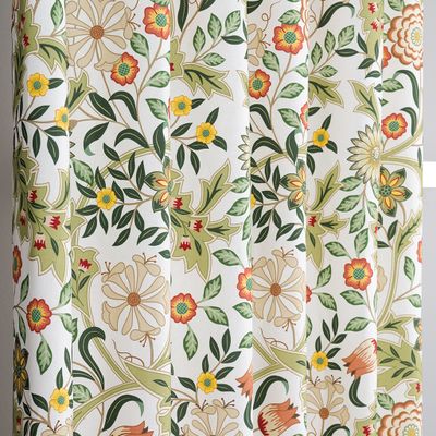 Detalj av gardintyg med klassiskt blommönster i grönt och varma färger