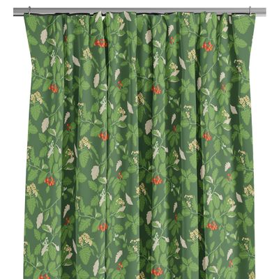 Närbild av Oxel grön gardin med mönster av oxelblad, vita blommor och röda bär mot grön bakgrund.