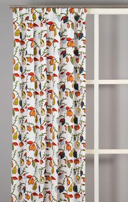 Ljusa gardiner med färgstarkt naturmönster upphängda vid fönster.