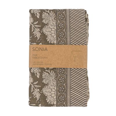 Hopvikt bordduk i varma latte-toner med blommigt mönster och dekorativ kantbård.
