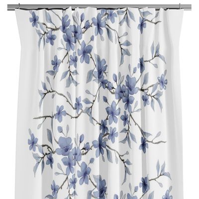 Blå blommiga gardiner med kvistar och blad på vit botten.