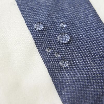 Närbild av Striato blå randig vaxduk med vattendroppar på den vattenavvisande ytan.