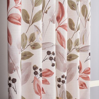 Närbild på Odessa-gardinens tyg med handmålade blad i grönt och terrakotta på naturvit botten.