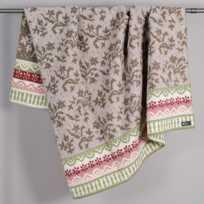 Torpet ullfilt upphängd som visar blommigt mönster och klassiska bårder inspirerade av svensk torpmiljö.