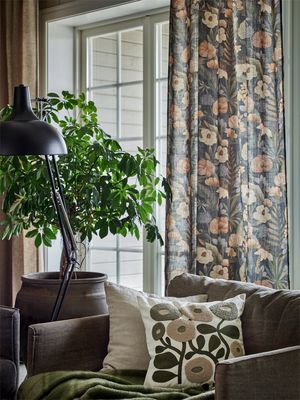 Cordoba svart gardin med botaniskt mönster upphängd vid fönster i vardagsrum med gröna växter