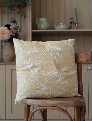 Tilda kuddfodral i gult, beige, grönt och rosa staplade på stol