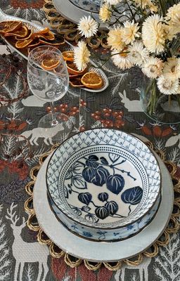 Hjortnäs löpare med skogens djur på ett dukat bord med blåvitt porslin, glas, torkad apelsin och ljusa blommor