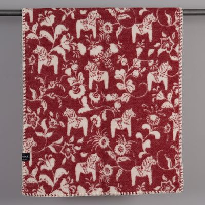 Leksand röd ullpläd 65x95 cm upphängd med klassiskt mönster av dalahästar och kurbits