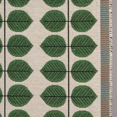 Närbild på Berså jacquard grön som visar den vävda strukturen och det invävda bladmotivet.