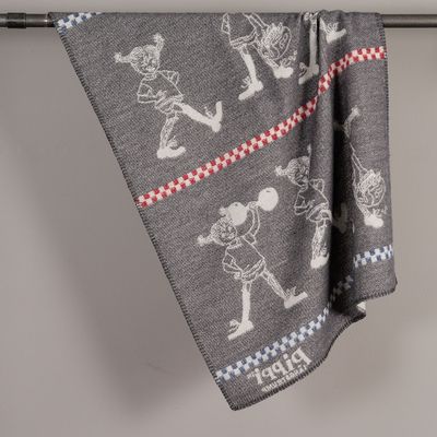 Mörkgrå baksida av Pippi barnpläd i merinoull med inverterade motiv och röda samt blå detaljer