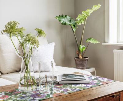 Bordslöpare med friskt blom- och bladmönster mot vit bakgrund, svensktillverkad i GOTS-certifierad ekologisk textil