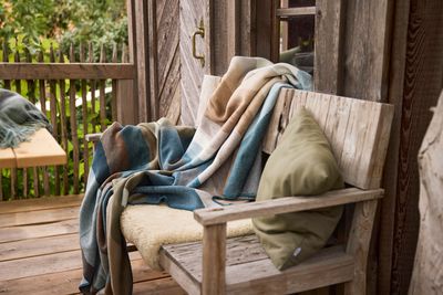 Mönstrad filt draperad över träbänk i rustik utomhusmiljö