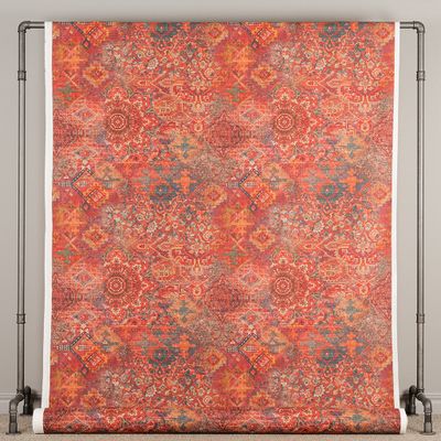 Persian tyg upphängt i full bredd med upprepade orientaliska mattmotiv i rött, orange och blågrått
