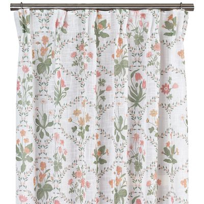 Vita gardiner med blommigt mönster i grönt, rosa och gult upphängda på gardinstång