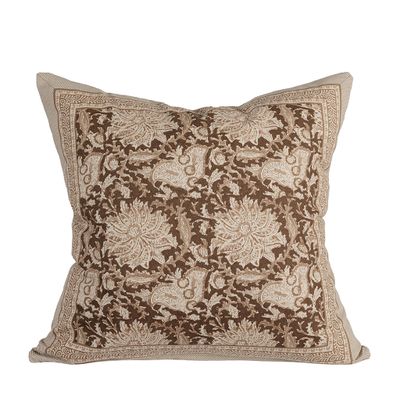 Kuddfodral med dekorativt blommönster och ornamenterade detaljer i nougat, beige och bruna toner mot vit bakgrund.