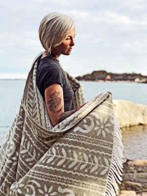 Tjej insvept i ANNO 1862 brun/vit ullpläd