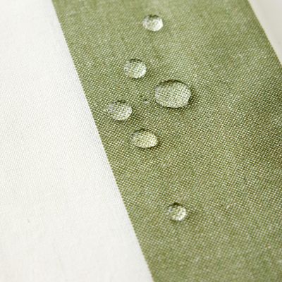 Närbild av Striato grön randig vaxduk med vattendroppar på den vattenavvisande ytan.