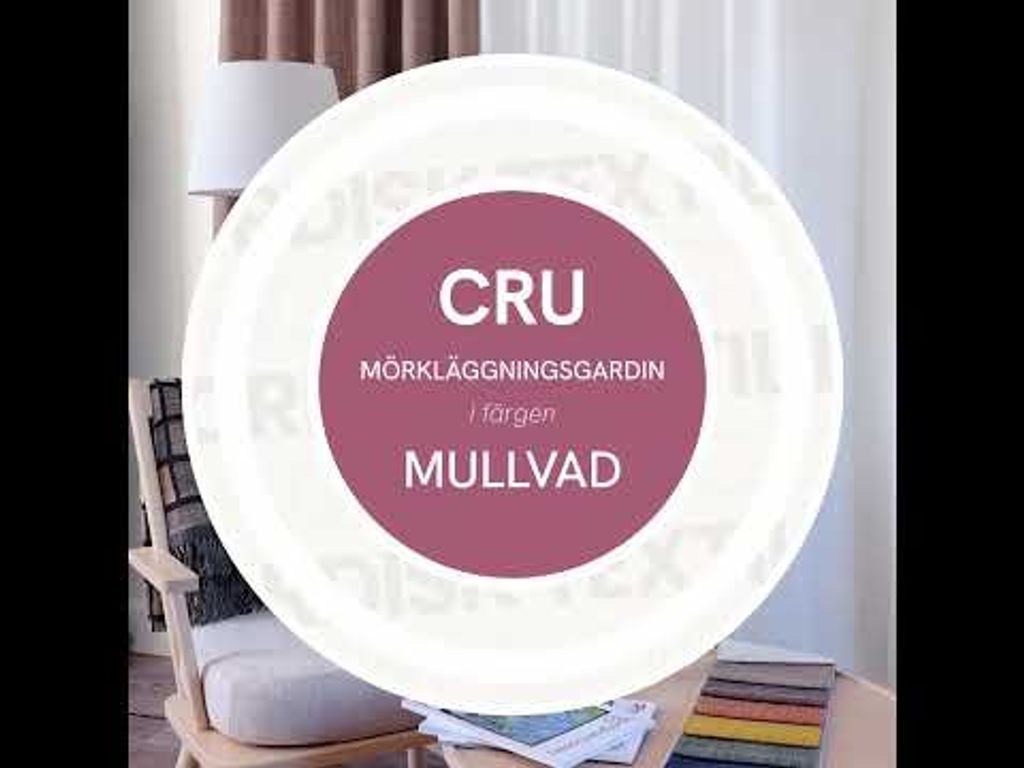 Video med mjuk panorering i vardagsrumsmiljö med Cru mullvad mörkläggningsgardin, ljus fåtölj med prickig kudde, pläd, kaffekopp med lätt ånga och tygprover på runt bord.