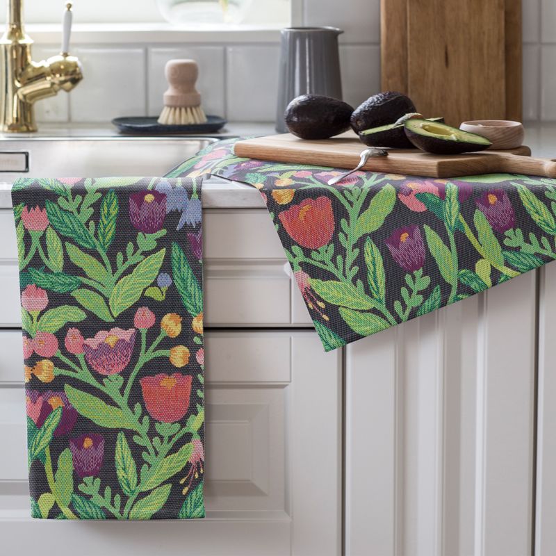 Svensk design handduk med färgstarka blommor och blad, tillverkad i hållbart ekologiskt material.
