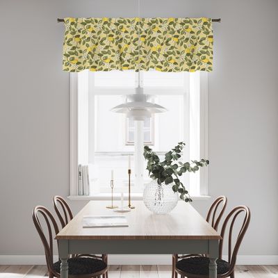 Gul gardinkappa med citronmönster upphängd i ett ljust kök ovanför ett fönster och matbord