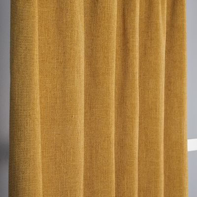 Närbild av ockragult mörkläggningstyg med tydlig och rik struktur.