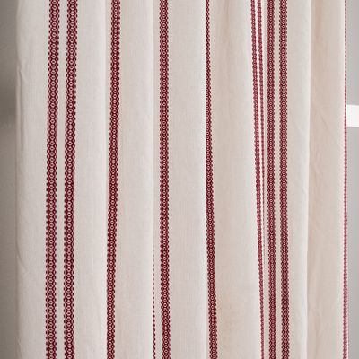 Närbild på gardinen Hedvig i offwhite som visar de vävda röda ränderna och tygets struktur.