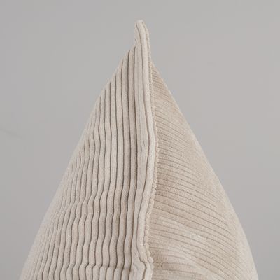 Närbild från sidan av Owen beige kuddfodral med mjuk ribbad manchesterstruktur och dekorativ kant