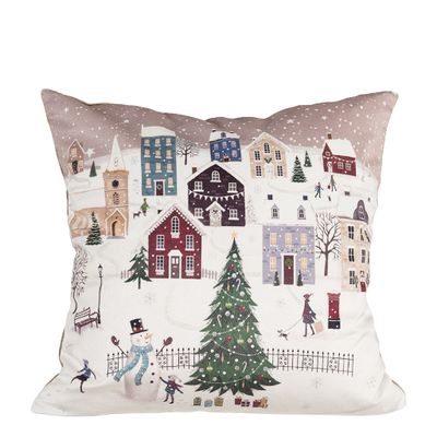 Julby kuddfodral med snötäckt by, färgglada hus, pyntad julgran, snögubbe och människor i ett stämningsfullt vinterlandskap.