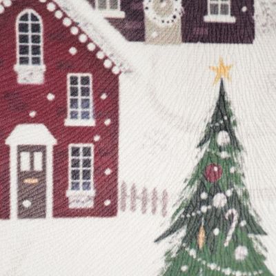 Närbild på Julby kuddfodral som visar den mjuka, sammetsliknande kvaliteten och detaljer i motivet med hus och pyntad julgran.