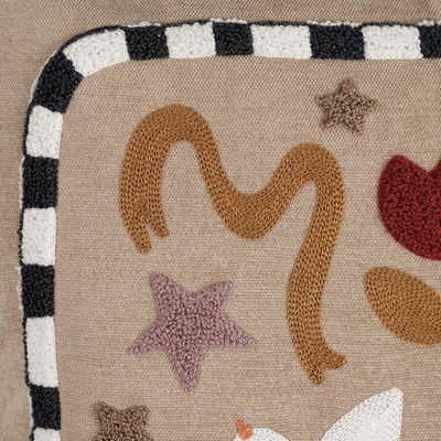 Närbild av Kuddfodral Paloma som visar broderade stjärnor och dekorativa former samt den svartvita kanten på beige tyg.