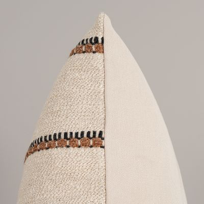 Detaljbild av Kuddfodral Paul med närbild på den strukturerade beige väven och den svartbruna dekorativa randen.