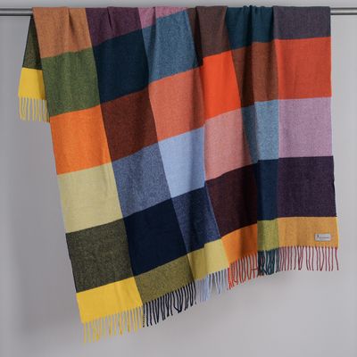 Rutig filt i flera färger hängande över stång