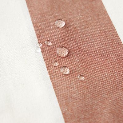 Närbild av Striato randig vaxduk där vattendroppar ligger på den vattenavvisande ytan.