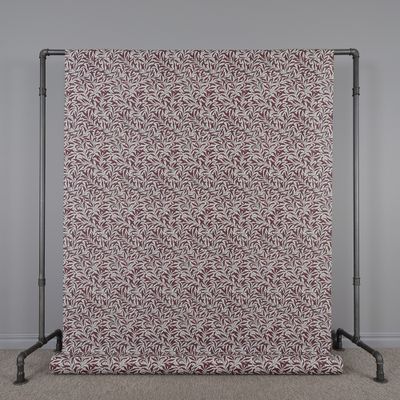 Upphängd textilvaxduk Ester med vinröda och sandfärgade blad i återkommande mönster över hela duken.