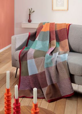 Färgglad Colour-Woven filt med sammetsband draperad över soffa i modern hemmiljö