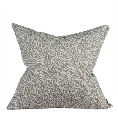 Ramasino kuddfodral i grönt med dekorativt bladmönster på ljus botten.